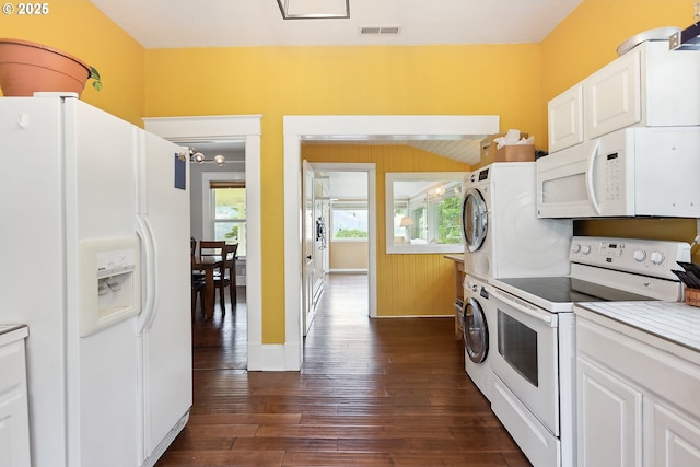 1006 4th Ave, Mosier, OR 97040 - kitchen with white appliances, stacked washing machine and dryer, dark wood-style flooring, white cabinetry, and light countertops