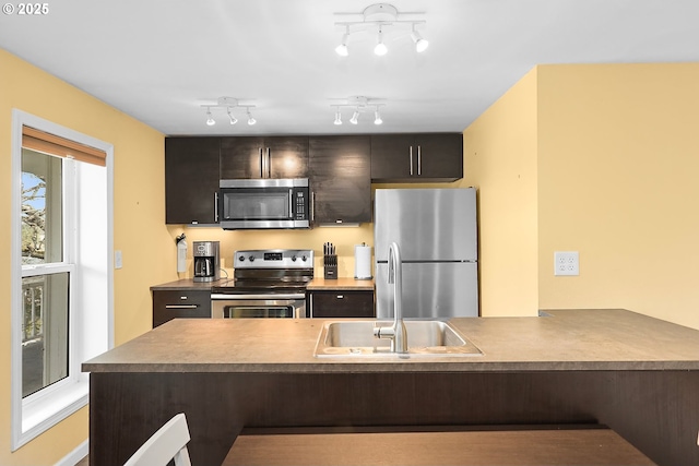 1006 4th Ave, Mosier, OR 97040 - kitchen with stainless steel appliances, a sink, a kitchen breakfast bar, dark brown cabinetry, and a peninsula