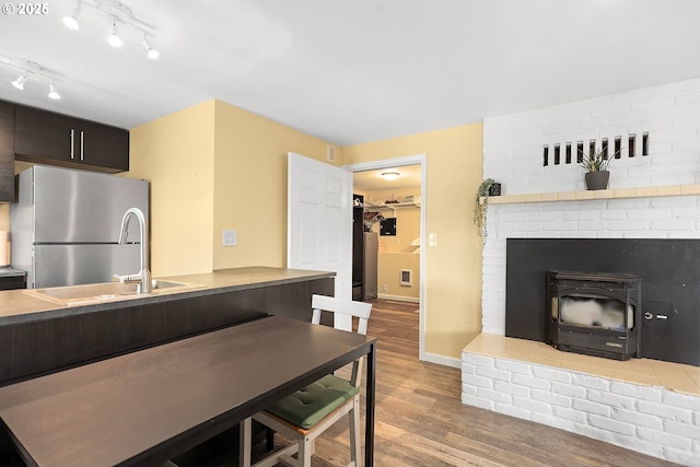 1006 4th Ave, Mosier, OR 97040 - kitchen featuring freestanding refrigerator, wood finished floors, a sink, dark brown cabinetry, and baseboards