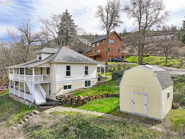 1006 4th Ave, Mosier, OR 97040 - back of house with stairs, a shed, an outdoor structure, and a shingled roof