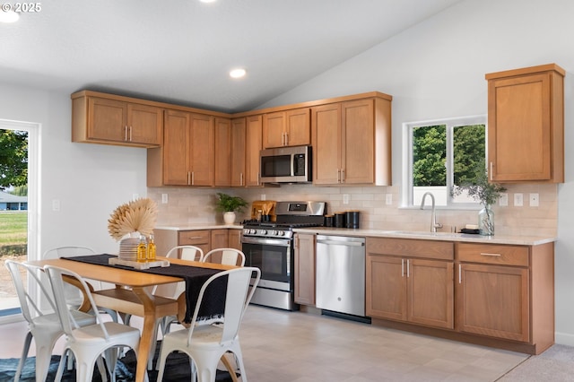 kitchen with sink, backsplash, lofted ceiling, and stainless steel appliances