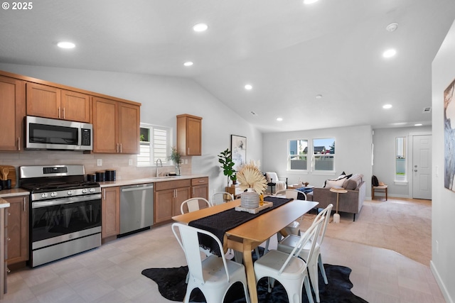 kitchen with light carpet, sink, backsplash, stainless steel appliances, and lofted ceiling