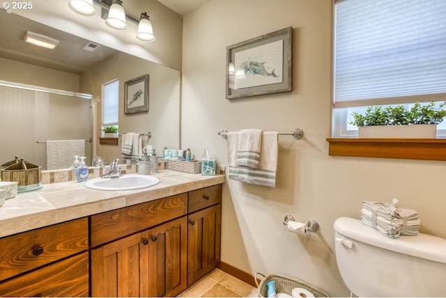 bathroom with tile patterned flooring, vanity, an enclosed shower, and toilet