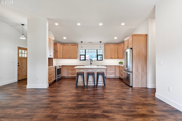 kitchen featuring pendant lighting, appliances with stainless steel finishes, a center island, lofted ceiling, and a breakfast bar area