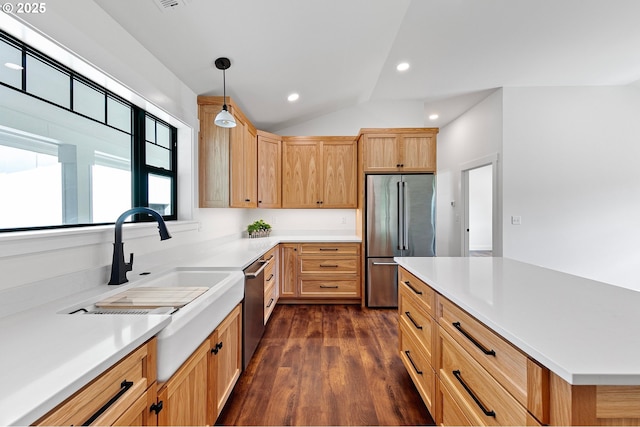 kitchen featuring light brown cabinets, pendant lighting, appliances with stainless steel finishes, dark hardwood / wood-style floors, and lofted ceiling