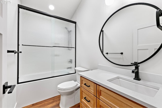 full bathroom featuring vanity, toilet, bath / shower combo with glass door, and wood-type flooring