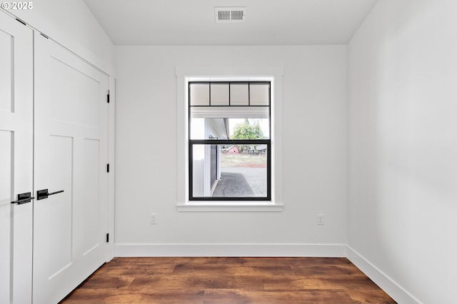 unfurnished room with dark hardwood / wood-style flooring