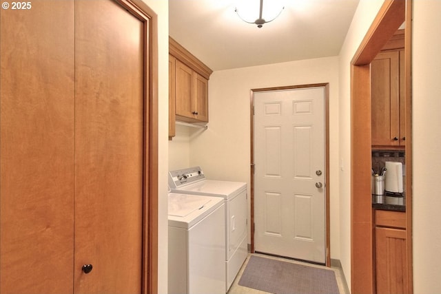 washroom featuring cabinets and washing machine and clothes dryer