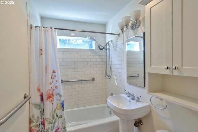 bathroom featuring shower / bath combination with curtain and sink