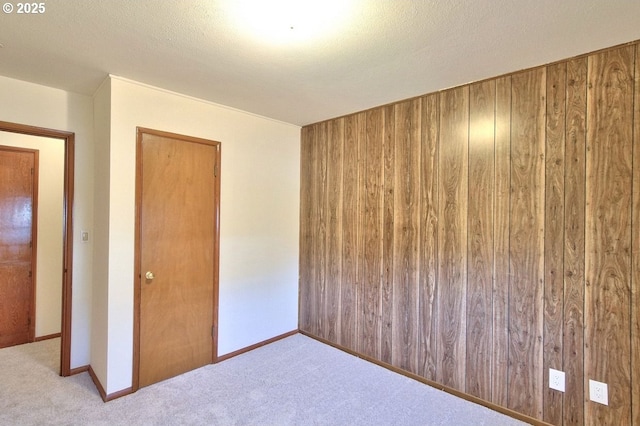 carpeted spare room with wood walls