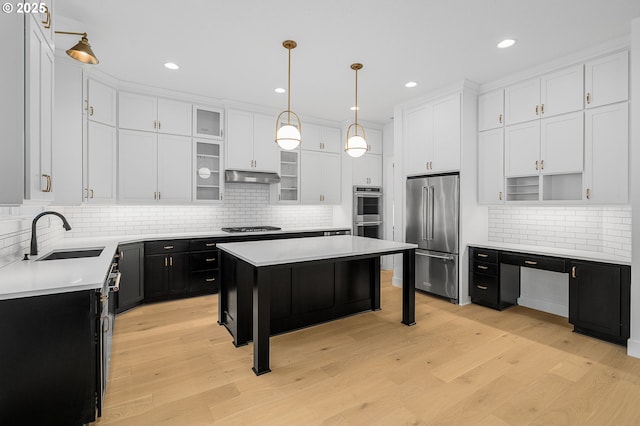 kitchen featuring a sink, appliances with stainless steel finishes, white cabinetry, and dark cabinets