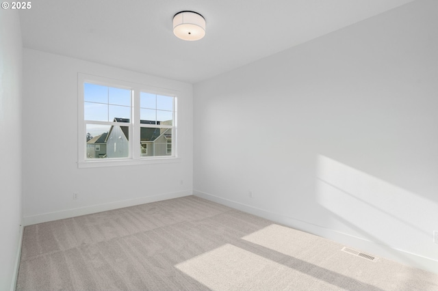 empty room with visible vents, baseboards, and carpet