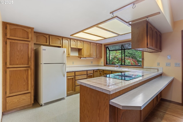 1705 SW 24th Dr, Gresham, OR 97080 - kitchen featuring freestanding refrigerator, a sink, a peninsula, black electric stovetop, and brown cabinetry