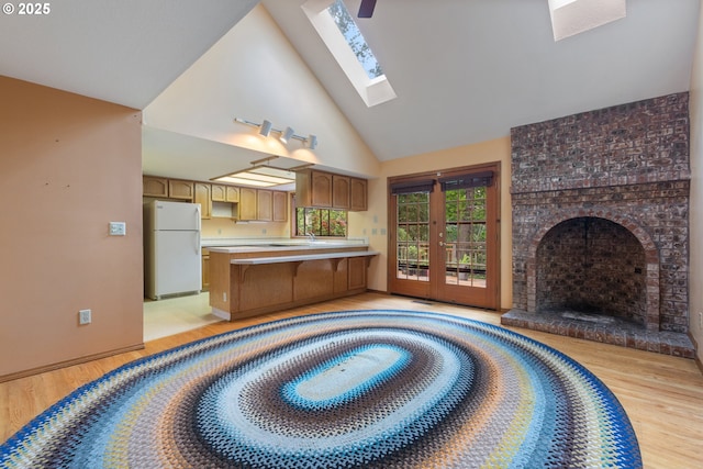 1705 SW 24th Dr, Gresham, OR 97080 - kitchen featuring freestanding refrigerator, light wood-style floors, high vaulted ceiling, a peninsula, and light countertops