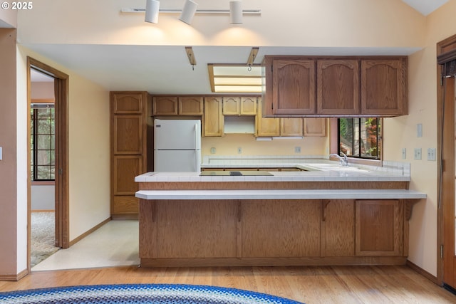 1705 SW 24th Dr, Gresham, OR 97080 - kitchen with freestanding refrigerator, healthy amount of natural light, a peninsula, and light wood-style floors
