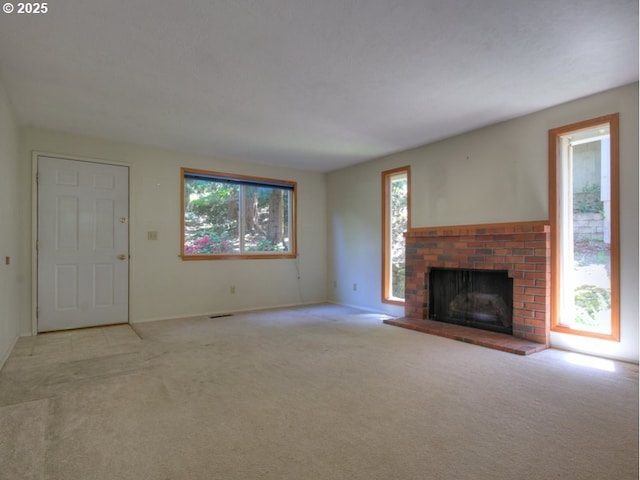 9435 SW 53rd Ave, Portland, OR 97219 - unfurnished living room featuring healthy amount of natural light, a brick fireplace, light colored carpet, and baseboards