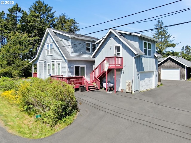 view of front of property featuring a deck, stairs, and a detached garage
