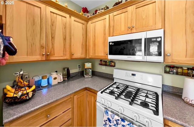 kitchen with white appliances and dark countertops