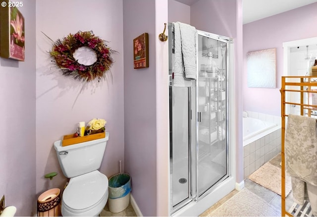 bathroom featuring a shower stall, a garden tub, tile patterned flooring, and toilet