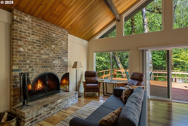 25050 Wilson River Hwy, Tillamook, OR 97141 - living room featuring wooden ceiling with exposed beams, hardwood / wood-style flooring, high vaulted ceiling, and a brick fireplace