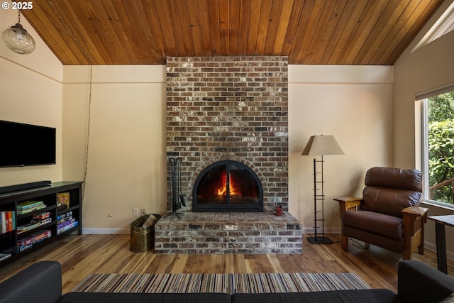 25050 Wilson River Hwy, Tillamook, OR 97141 - living area with lofted ceiling, wood finished floors, a brick fireplace, wood ceiling, and baseboards