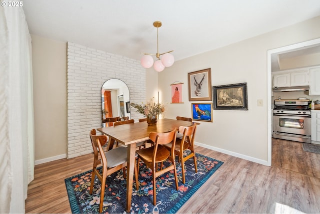 16523 NE Fargo Cir, Portland, OR 97230 - dining room with arched walkways, light wood-style flooring, baseboards, and brick wall