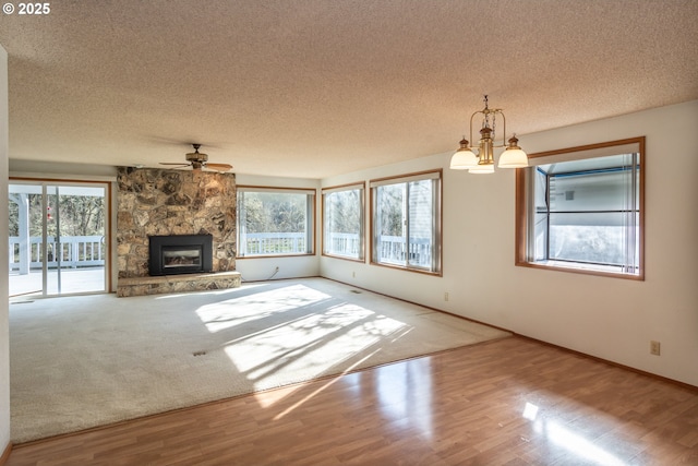 unfurnished living room featuring a textured ceiling, a fireplace, and wood finished floors