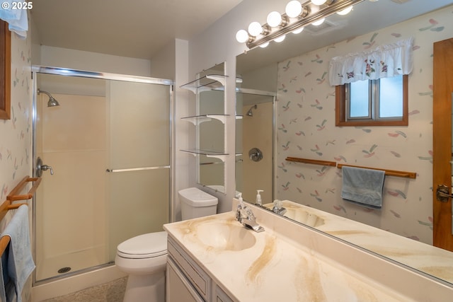 bathroom with a stall shower, vanity, toilet, and wallpapered walls