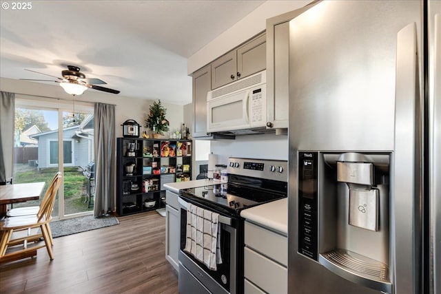 kitchen with stainless steel appliances, ceiling fan, gray cabinets, and dark hardwood / wood-style floors