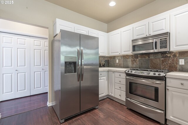 kitchen with stainless steel appliances, light countertops, white cabinets, backsplash, and dark wood-style floors