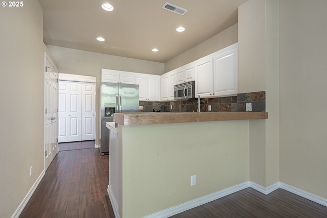 kitchen with appliances with stainless steel finishes, white cabinetry, dark wood-style floors, recessed lighting, and baseboards