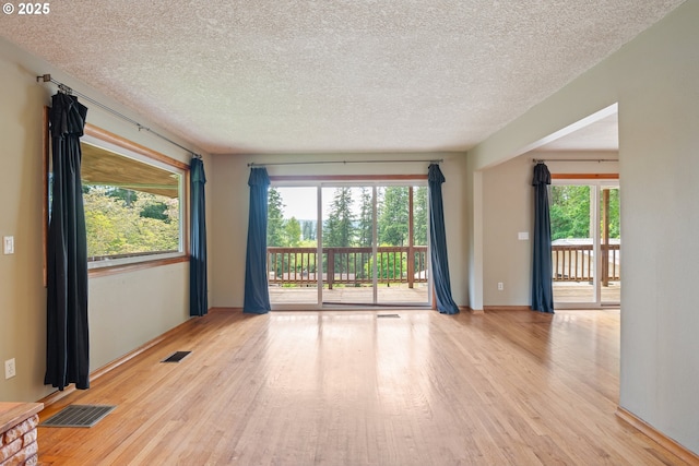 112 Paine Rd, Castle Rock, WA 98611 - empty room with wood finished floors, healthy amount of natural light, a textured ceiling, and baseboards