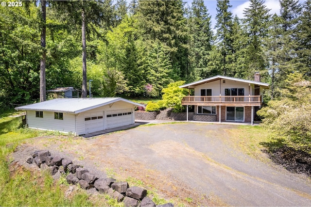 112 Paine Rd, Castle Rock, WA 98611 - view of front facade featuring an outbuilding, a garage, a deck, and a wooded view