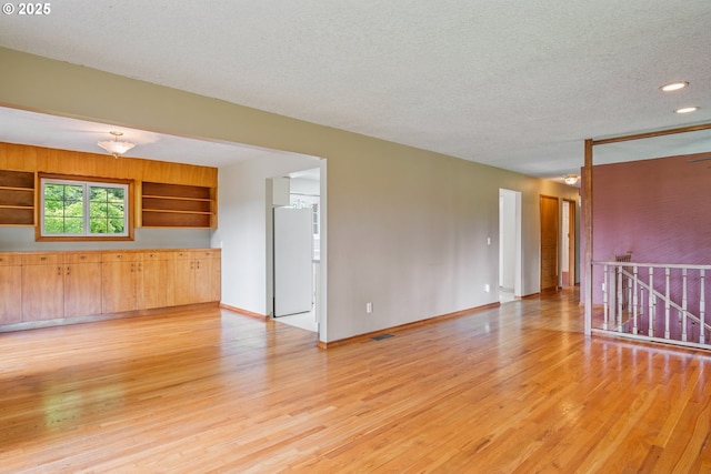 112 Paine Rd, Castle Rock, WA 98611 - unfurnished room with light wood finished floors, a textured ceiling, baseboards, and recessed lighting