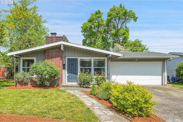 view of front of home featuring a chimney, brick siding, a garage, driveway, and a front yard