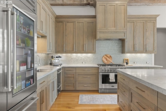 2193 NE 3rd Ave, Camas, WA 98607 - kitchen with stainless steel appliances, light wood-style floors, decorative backsplash, range hood, and light stone countertops