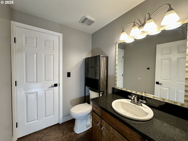 bathroom featuring toilet, vanity, visible vents, and tile patterned floors