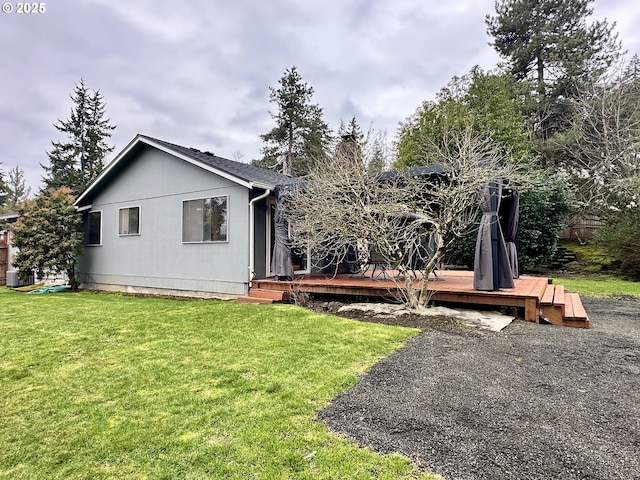 back of property featuring a yard, a chimney, and a wooden deck