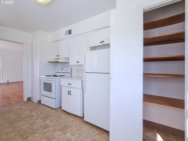 kitchen featuring white appliances, under cabinet range hood, white cabinets, and visible vents