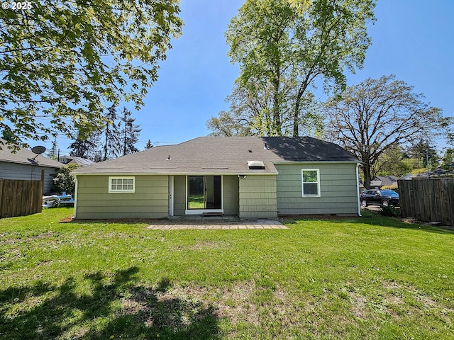 back of house featuring fence, a patio, a shingled roof, and a yard