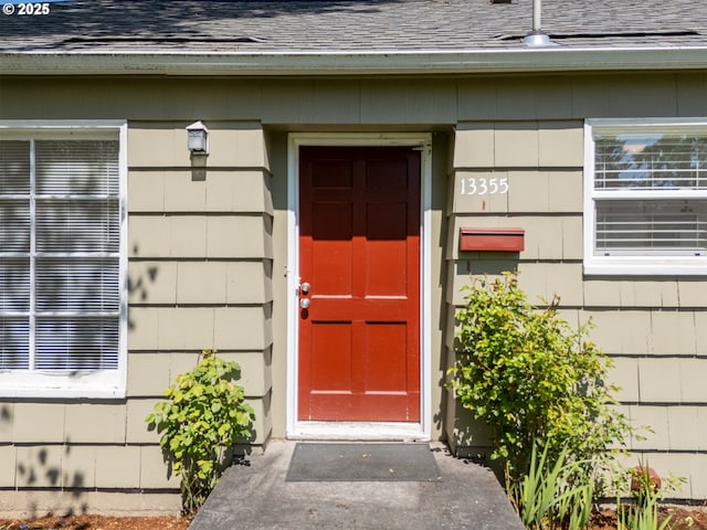 property entrance with a shingled roof