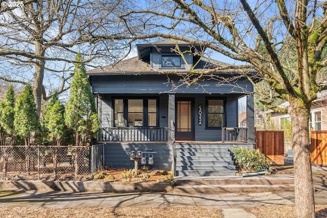 bungalow-style home with covered porch and fence