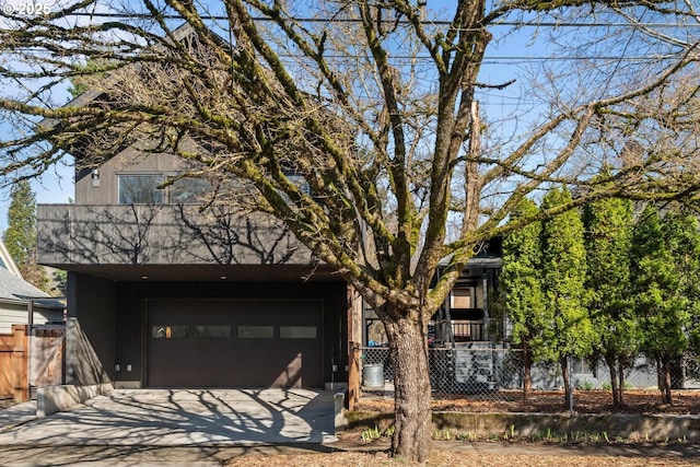 view of front facade with a garage, fence, and driveway