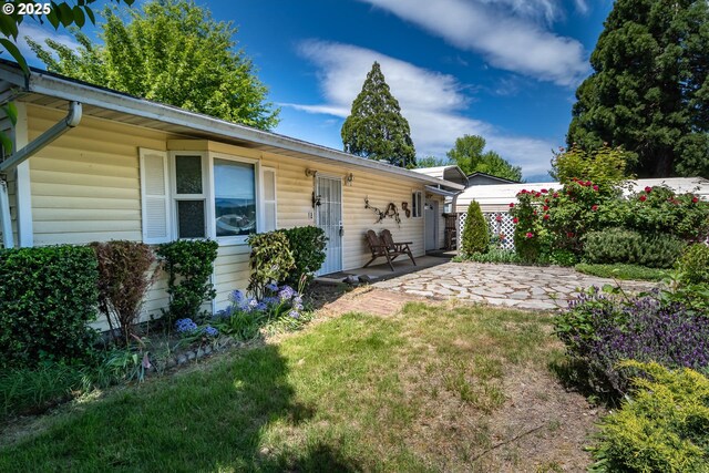 back of house with a patio area and a lawn
