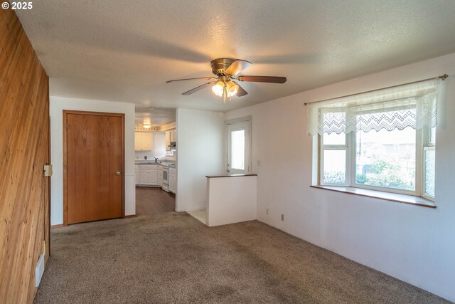 carpeted empty room with a textured ceiling and ceiling fan