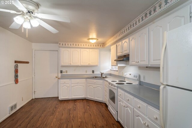 kitchen featuring white appliances, a sink, white cabinetry, dark wood-type flooring, and under cabinet range hood
