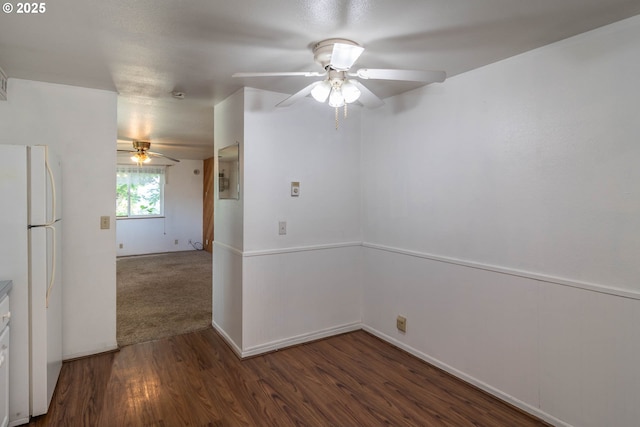 empty room with a ceiling fan, wood finished floors, and baseboards