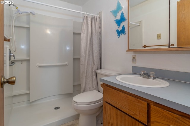 bathroom with a stall shower, vanity, and toilet