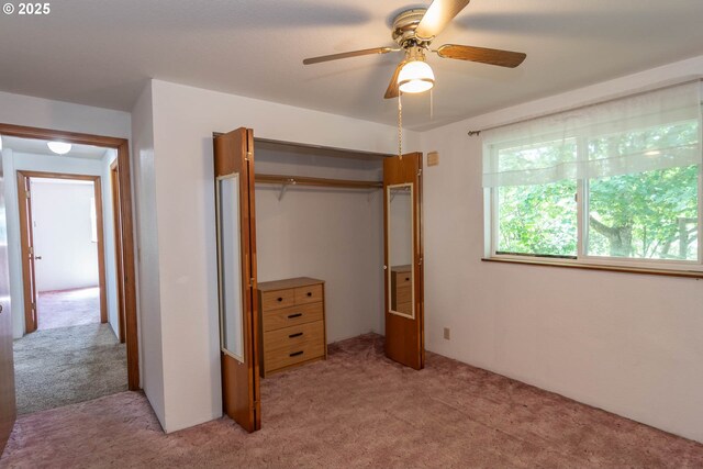 unfurnished bedroom featuring light carpet, a closet, and a ceiling fan