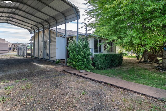view of parking / parking lot featuring a carport and fence